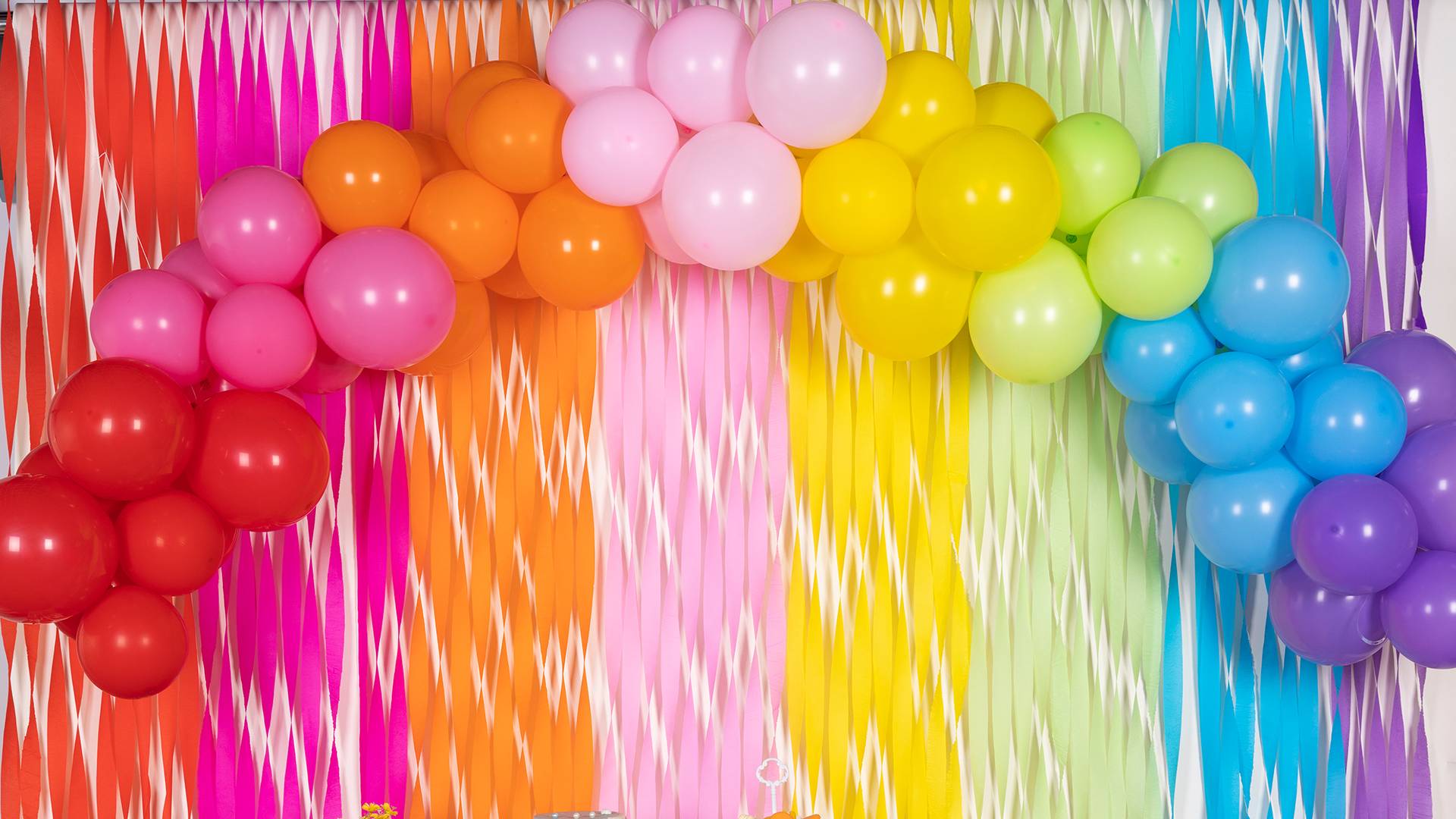 This arch is composed of an assortment of colorful balloons arranged in a curved shape, resembling a captivating rainbow.