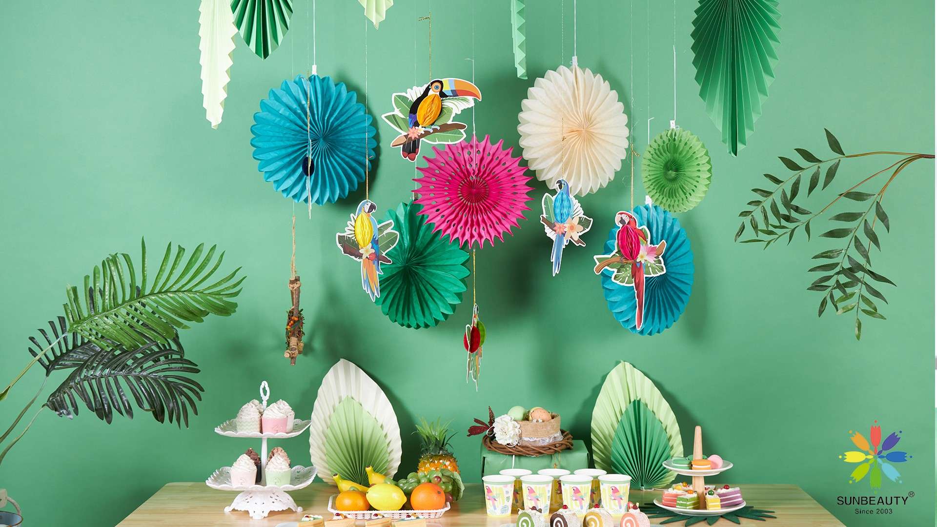 Vibrant summer decorations featuring toucan paper fans and leaf-shaped paper fan decorations.