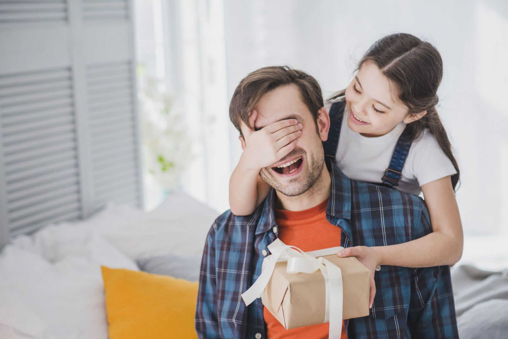 fathers day concept with daughter covering fathers eyes