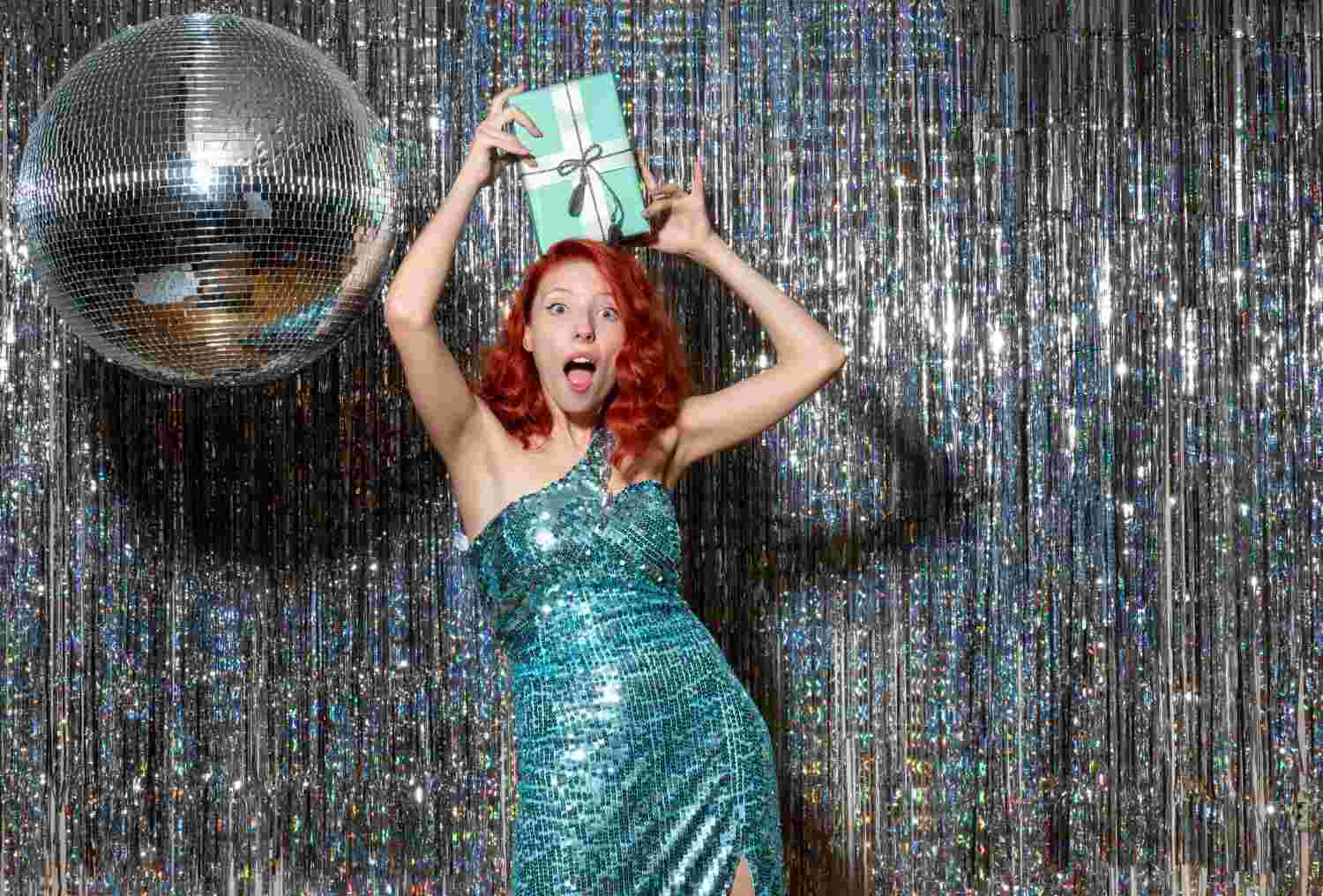 young woman celebrating new year holding present party bright curtains