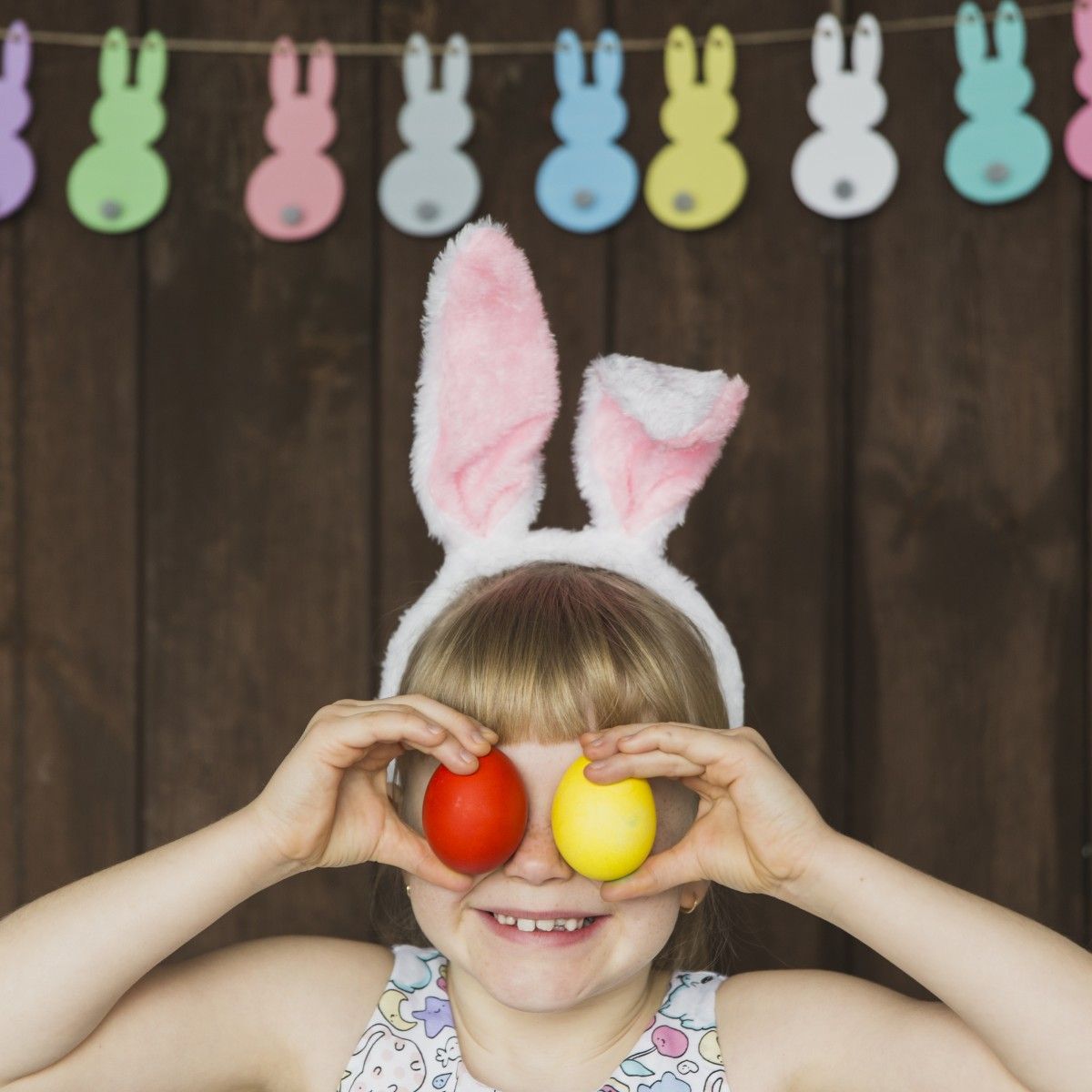 playful girl posing with colored eggs