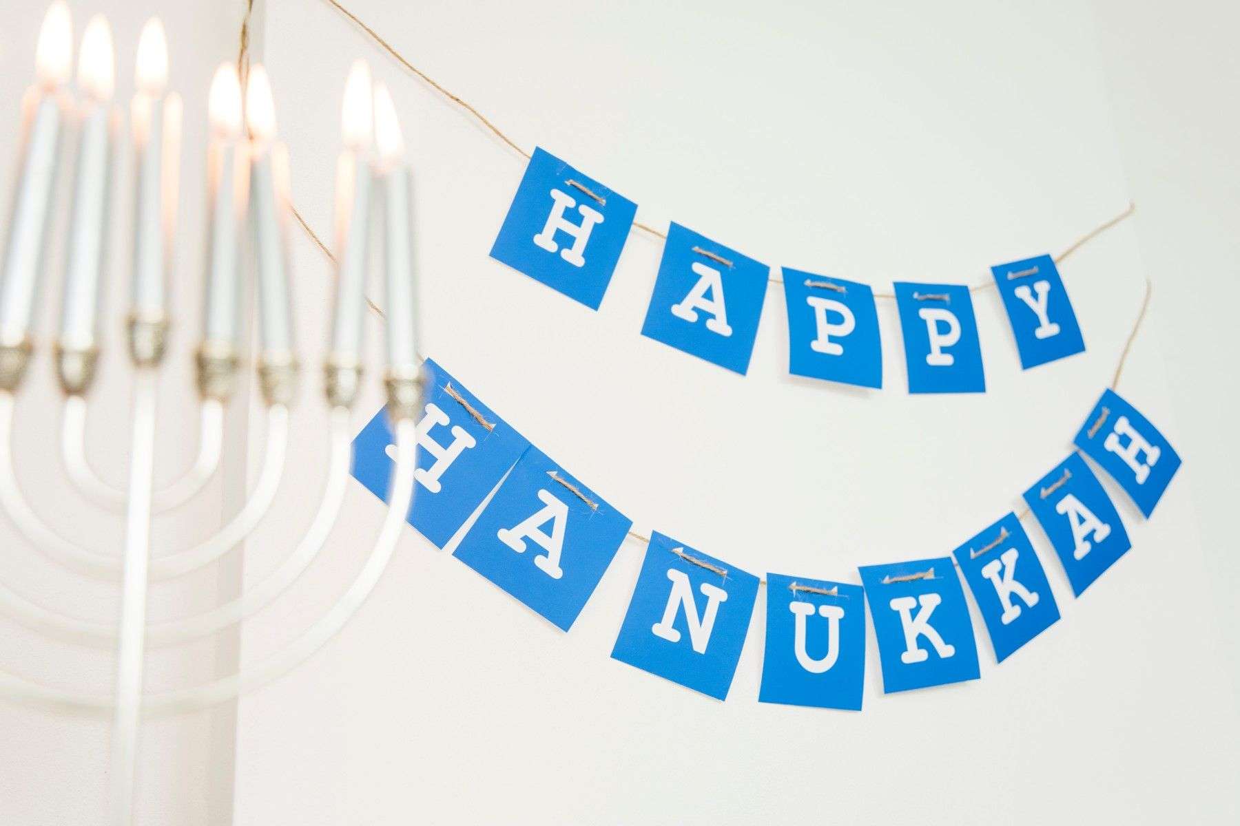 burning candles near happy hanukkah garland eid banner